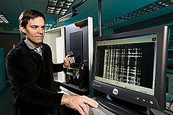 Geneticist loads an automated DNA sequencer for genetic analysis: Click here for full photo caption.