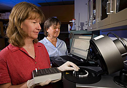 Technician (left) and plant pathologist load samples for quantitative PCR analysis: Click here for full photo caption.