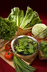 Produce and leafy greens shown (clockwise from top): romaine lettuce, cabbage, cilantro in a bed of broccoli sprouts, spinach and other leafy greens, green onions, tomatoes, and green leaf lettuce: Click here for full photo caption.