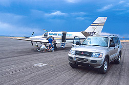 Several scientists load equipment on a twin-engine Cessna plane: Click here for full photo caption.