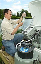Agricultural engineer examines discharge water from a turfgrass system in central Ohio: Click here for full photo caption.