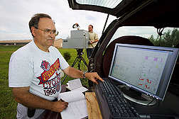 Chemist observes the spectra of gases obtained from an infrared spectrometer unit positioned adjacent to a swine facility: Click here for full photo caption.