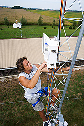 Soil scientist climbs a 30-meter tower to inspect air-sampling equipment: Click here for full photo caption.