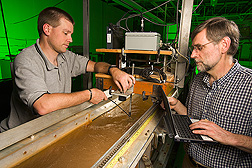 Technician adjusts the acoustic sensor while hydraulic engineer prepares to collect data on the model stream channel at the National Sedimentation Laboratory: Click here for full photo caption.