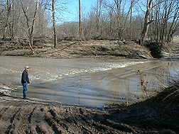 A cooperator with Missouri Corn Growers surveys a section of Long Branch Creek in Missouri: Click here for full photo caption.