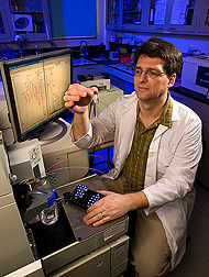 Molecular biologist uses a tandem mass spectrometer, which collects the data necessary for proteomics: Click here for full photo caption.