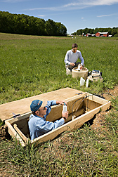 Hydrologist (right) and laboratory worker collect runoff water samples from a hillslope trench that is being used to monitor lateral subsurface flow pathways during and after storms: Click here for full photo caption.