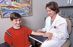 Study nurse draws blood from a study participant: Click here for full photo caption.
