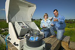 Technician and agricultural engineer take notes on a sample of water: Click here for full photo caption.