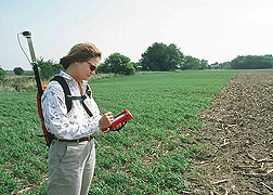 Hydrologist uses a global positioning system to record the status of a filter strip planting: Click here for full photo caption.