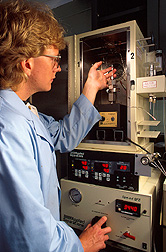 Chemist adjusts the pressure-control gauge on a device while a biocatalysis reaction occurs inside. Click here for full photo caption.