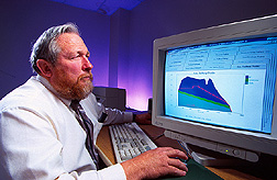 Researcher examines output from a software program used for predicting the performance of spillways and designing new structures. Click here for full photo caption.