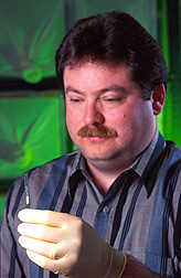 Chemist examines glass beads that have absorbed human scents. Click here for full photo caption.