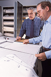 Chemist observes as chemical engineer prepares cotton samples: Click here for full photo caption.