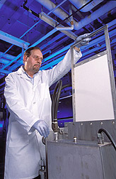 Chemical engineer inspects a sample of cotton fabric: Click here for full photo caption.