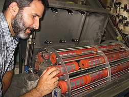 ARS ecologist inspects one of the sample tubes of a seed-bank elutriator: Click here for full photo caption.