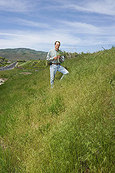 Agriculturalist studies a roadside bank covered in ripening cheatgrass in Utah: Click here for full photo caption.