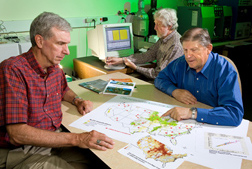 Soil scientist Ron Follett (right) examines a map of ARS soil carbon research sites across the United States while physical science technician Ed Buenger conducts mass spectrophotometer analysis of soil samples for carbon and nitrogen: Click here for photo caption.
