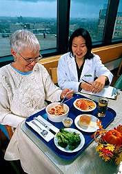 Dietitian instructs a study volunteer on the foods to be eaten as part of the metabolic study. Click here for full photo caption.