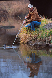 Technician Jeff Nichols collects a water sample from the Walnut Creek watershed. Click here for full photo caption.