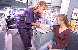 Technician collects blood sample from a seventh grader: Click here for full photo caption.