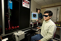 Agricultural engineer (front) and visiting assistant professor (from Michigan State University) test a laser-based multispectral imaging prototype that detects apple firmness and sugar content: Click here for full photo caption.