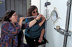 Entomologist Judy Johnson (left) and technician Karen Valero use tubes to insert moths into storage rooms. Click here for full photo caption.