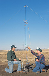 Soil scientist and biological science technician measure air flow rate through ammonia collectors: Click here for full photo caption.