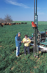 Technician and meteorologist perform a soil core extraction: Click here for full photo caption.