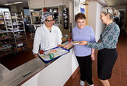 Nutrition technician (left) and nutritional biochemist (right) discuss a study diet with a participant: Click here for full photo caption.