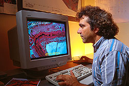 Computer specialist analyzes an aerial color-infrared digital video image. Click here for full photo caption.