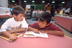 Two Navajo children reading in library: Click here for full photo caption.