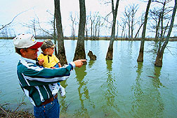 Floyd Anderson, Jr., and his son check out fishing holes in Thighman Lake. Click here for full photo caption.