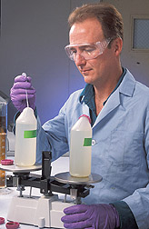 Chemist prepares to use a centrifuge to harvest cyanobacteria and algae: Click here for full photo caption.