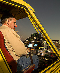 Pilot activates cameras located in agricultural aircraft with a remote control strapped to his leg: Click here for full photo caption.