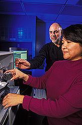 Research leader and engineer place tsetse fly pupae in an automated scanning and sorting system: Click here for full photo caption.