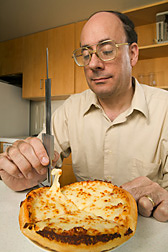 Chemist measures the stretchability of low-fat mozzarella cheese on a commercial take-out pizza: Click here for full photo caption.