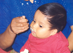 Porridge being fed to an infant: Click here for full photo caption.