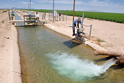 ARS electrical engineer (left), ARS hydraulic engineer (right), and student (center) were able to test ARS-developed software on real canals such as this one near Eloy, Arizona: Click here for full photo caption.