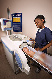 A research assistant prepares to place a sleeping infant into the measurement chamber of the PEA POD, a specialized instrument for accurately measuring infant body fat: Click here for full photo caption.