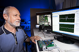 Entomologist Richard Mankin examines signals collected by an inexpensive prototype system (on the bench, at his fingertips) for automated insect detection and identification: Click here for photo caption.