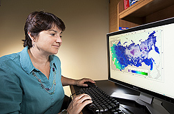 Plant geneticist Stephanie Greene examines a digital map of absolute minimal temperature: Click here for full photo caption.