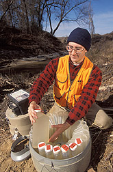Biologist removes water quality samples from an automated water sampler: Click here for full photo caption.