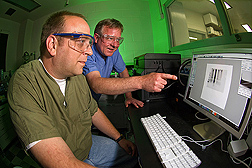 Chemist (left) and veterinary medical officer discuss a Western blot image from a TSE test of formalin-fixed tissues: Click here for full photo caption.