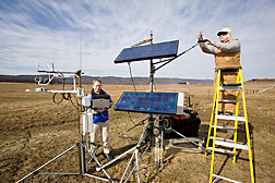 Plant physiologist (left) and technician check sensors and download carbon dioxide flux data from an eddy covariance system on a pasture at Penn State, Haller research farm: Click here for full photo caption.