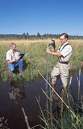 Rangeland scientist and wildlife program manager measure streamflow: Click here for full photo caption.