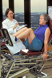 Woman using exercise equipment: Click here for full photo caption. 