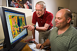 Two agricultural engineers evaluate a soil electrical conductivity map to estimate field nutrient levels and salinity in a vegetative treatment area: Click here for full photo caption.