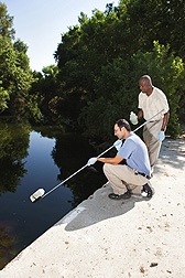 Technician Damon Baptista (left) and microbiologist Mark Ibekwe collect a water sample from a creek that drains into the middle Santa Ana River Watershed: Click here for full photo caption.