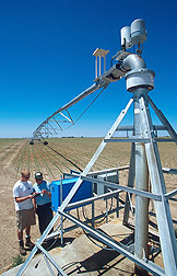 A research leader downloads data about the movement of a center-pivot irrigation system. Click here for full photo caption.